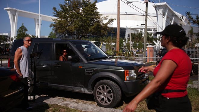 Alex and Lourdes Zimmerman charge people $30 to park on their property along NW 4th Street before the Marlins' first regular-season game at Marlins Park.