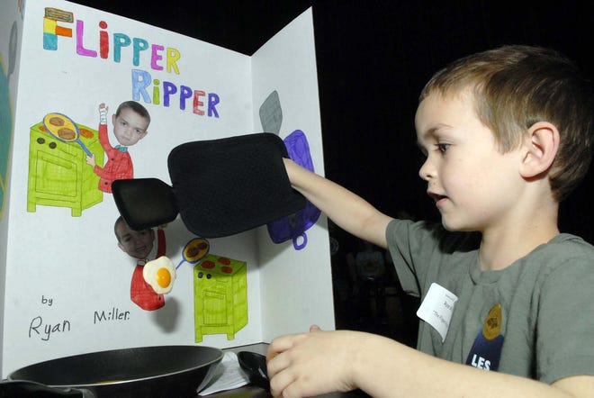 Ryan Miller, a first-grader at Lebanon Elementary School, explains how he uses a cloth to protect his arm from being burned while flipping eggs Wednesday at the school's annual Invention Convention.