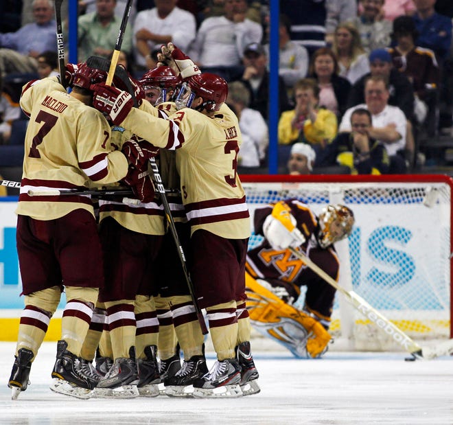 Boston College players including Isaac MacLeod (7) and Patch Alber (3) celebrate a goal as Minnesota goalie Kent Patterson reacts in the background during the third period of the Eagles' 6-1 win on Thursday night in the semifinals of the Frozen Four.