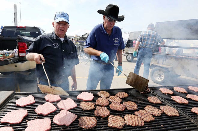 Iowa Cattlemen's Association members Ted Paulsrud, left, and Kevin Carstensen cook hamburger patties made with lean, finely textured beef, also known as "pink slime," produced by Beef Products Inc. at Tyson Events Center in Sioux City, Iowa.
