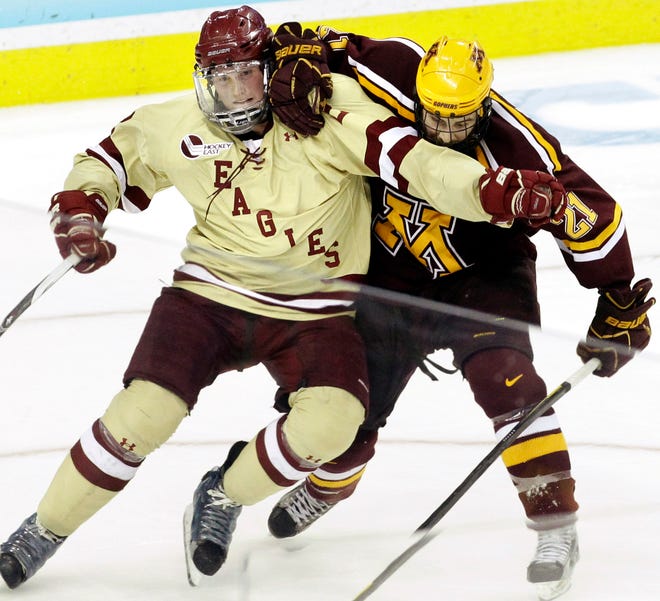 Boston College's Brian Dumoulin (left) battles for position against Minnesota's Jake Hansen in the second period of an NCAA Frozen Four college hockey tournament semifinal game on Thursday in Tampa.