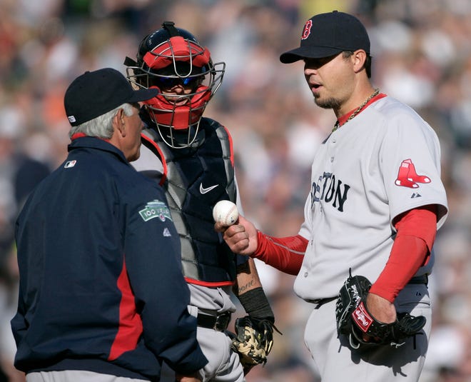 Red Sox starter Josh Beckett (right) hands the ball to manager Bobby Valentine after allowing back-to-back home runs to the Tigers.
