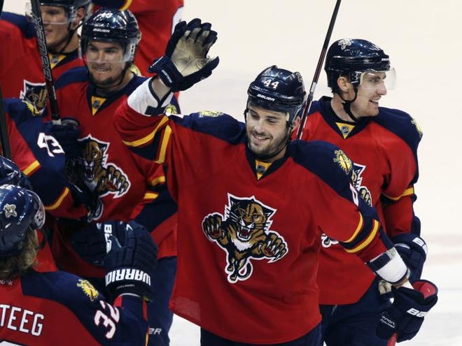 Florida Panthers' Erik Gudbranson, center, celebrates with teammates after defeating the Carolina Hurricanes 4-1 during an NHL hockey game in Sunrise, Fla., Saturday, April 7, 2012.