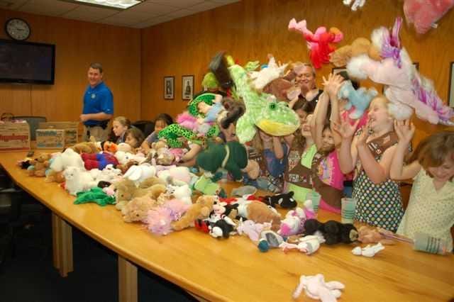 Girl Scouts of Troop 1165 toss stuffed animals in the air in celebration of collecting more than 150 cuddly creatures for the St. Johns Sheriff's Office Cuddly Care program. Contributed photo.