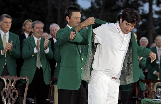 Charl Schwartzel, left, helps Bubba Watson put on the green jacket Sunday after Watson won the Masters on the 10th hole after a sudden death playoff in Augusta, Ga.