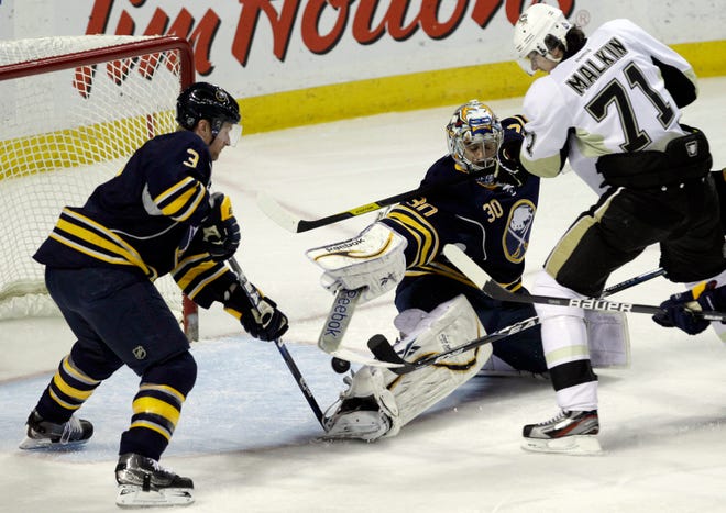 Pittsburgh Penguins' Evgeni Malkin (71) scores on Buffalo Sabres goalie Ryan Miller under pressure from Sabres' Jordan Leopold (3) during the first period of an NHL hockey game in Buffalo, N.Y., Friday, March 30, 2012. The Penguins won 5-3. (AP Photo/Devin Duprey)