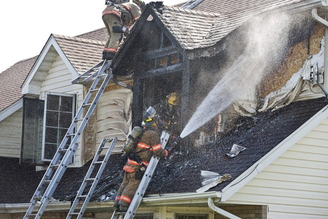 Springfield firefighters extinguish any remaining hot spots on the second story of a house fire at 1921 Strawberry Lane in Springfield, Ill., Monday, April 9, 2012. A Springfield firefighter was taken to Memorial Medical Center today after suffering burns to his hand while battling the fire. Justin L. Fowler/The State Journal-Register