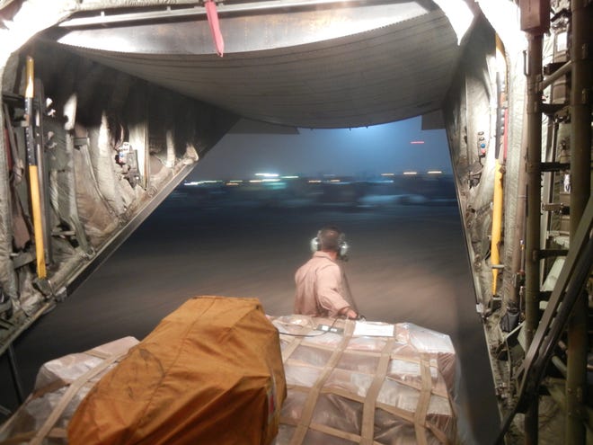 On a warm night in the United Arab Emirates, AWF2 Chris Vargas awaits a specialized flatbed truck called a "K-loader" so he can finish unloading cargo from Nomad 313.