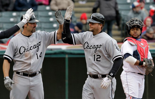With Cleveland Indians catcher Carlos Santana watching at right, Chicago White Sox's A.J. Pierzynski (12) is congratulated by teammate Paul Konerko (14) after hitting a three-run home run in the sixth inning of a baseball game in Cleveland on Wednesday, April 11, 2012.