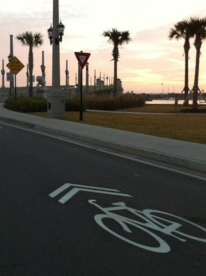 Sharrows indicating a road shared by cars and bicycles are seen on the pavement toward the Bridge of Lions. The sharrows are a result of the Velo Fest Community Initiative's efforts.