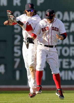 Boston Red Sox outfielders Darnell McDonald (left) and Cody Ross celebrate their 12-2 victory over the Tampa Bay Rays at Fenway Park yesterday.