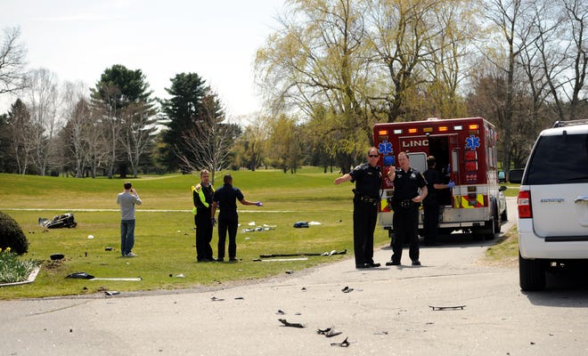 Police talk at the scene of Saturday afternoon's motorcycle accident at the entrance of the Nashawtuc Country Club on Sudbury Road, while the victim is tended to in the Lincoln Fire Dept. ambulance.