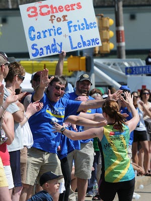 Keith Frisbee, of Dover NH, reaches out to hug his daughter, Carrie Frisbee, as she ran to help raise money for Team Dana Farber in tribute to her mother, Lauren, who is a cancer survivor, during the Boston Marathon Monday morning in Ashland.