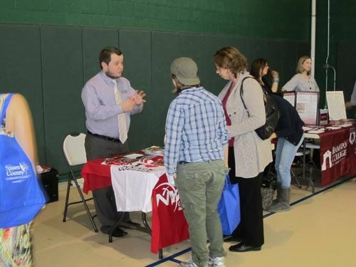 Photo by Rob Jenning/New Jersey Herald - Jonathon Shaffstall, admissions counselor at Nyack College, speaks with Suzette Houdershieldt of Vernon and her daughter, Emily, Wednesday at the college fair at Sussex County Community College.
