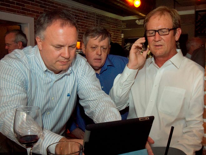 State Sen, J.D. Alexander R-Lake Wales, right, David Robinson, left, of Lakeland, and Al Cassidy, center, of Winter Haven look for news results on the Internet of Governor Rick Scott's decision on USF Polytechnic during a gathering of supporters for an independent USF Polytechnic at the Ave Bar By Arabellas in Winter Haven on Friday.