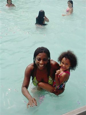 This Sunday, June 26, 2011 photo provided by Candella Matta shows Marie Joseph, foreground, holding family friend Dalianys Melendez, daughter of Candella Matta, in the public swimming pool at Lafayette Park in Fall River, Mass. The body of Marie Joseph, 36, was found floating in the pool late Tuesday. She was last seen at the pool Sunday and had not been seen since. Officials are investigating whether her body was in the pool for more than two days while other people continued to swim. (AP Photo/Candella Matta)