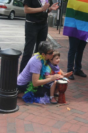 Allison Floyd / Staff Junot Cuomo-Schlanger,4, beats a bongo with Chris Cuomo while listening to speakers at the University of Georgia Arch on April 21, 2012, as part of a series of demonstrations billed as the Worldwide Lesbian, Gay, Bisexual and Transgender (LGBT) Civil Rights March. About 75 people participated here.