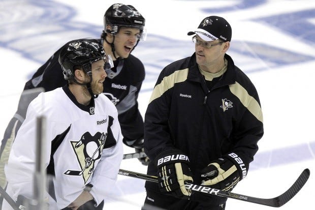 Penguins coach Dan Bylsma (right) talks with Joe Vitale (left) as Sidney Crosby skates behind them during practice April 17.