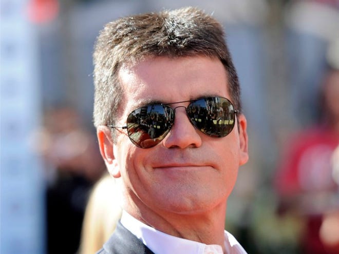 British entertainment mogul Simon Cowell arrives at the "American Idol" finale in Los Angeles on May 26, 2010. A revealing new biography offers intimate, some might say too intimate, details about Simon Cowell, along with a portrait of the entertainment mogul's savvy business side. "Sweet Revenge," published in the U.S. by Ballantine Books on Tuesday, April 21, 2012, is written by British journalist and biographer Tom Bower, and is the first book written about Cowell with his participation, though not his authorization. (AP Photo / Chris Pizzello, File)