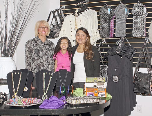 Jazzi Boutique ’n Nail Spa owner Cecilia Sharp, left, with granddaughter Jasmine Griffin, 3, whom the shop was named after, and nail specialist Teresa Rincon are pictured with a few of the items for sale in the boutique.