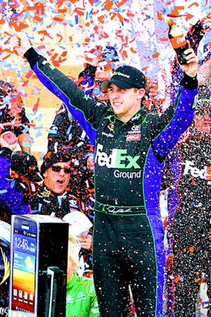 Denny Hamlin celebrates in Victory Lane after winning the NASCAR Sprint Cup Series race at Kansas Speedway.