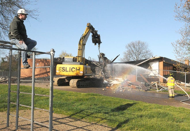 Rocco Eslich watches from the playground monkey bars as Louisville Elementary School is being demolished Tuesday.