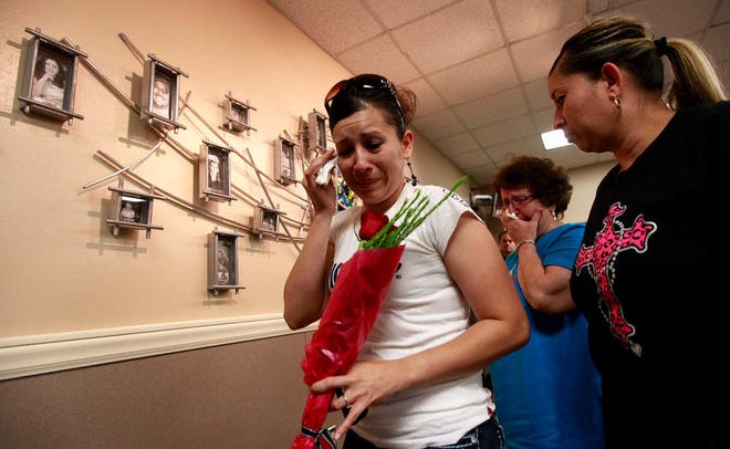 Jessica Hernandez, left, Ortica Bailon and Gloria Navarrete walk past the photo of their family member Daniel Perez, an organ donor, during a ceremony that unveiled University Medical Center's Donor Wall Friday. The wall presented photos of 18 donors that died and were able to donate their organs for others.(Lubbock Avalanche-Journal, Stephen Spillman)