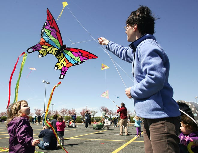 Sheila O'Mahony, 3, left, of Belmont, watches her mom, Kim, loosen the slack on her butterfly kite as Claire Mahony, 2, bottom right, watches from her stroller during Sunday's Celebrate Autism Awareness at the 11th annual Kite Day hosted by the Doug Flutie Jr. Foundation at Bose Mountain in Framingham.
