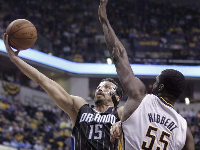 Orlando Magic forward Hedo Turkoglu, left, shoots under Indiana Pacers center Roy Hibbert in the first half of an NBA first round playoff basketball game in Indianapolis, Saturday, April 28, 2012.