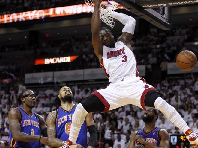 Miami Heat's Dwyane Wade (3) scores on a dunk as New York Knicks' Amare Stoudemire (1) and Tyson Chandler (6) look on in the first half of an NBA basketball game in the first round of the Eastern Conference playoffs in Miami, Saturday, April 28, 2012.