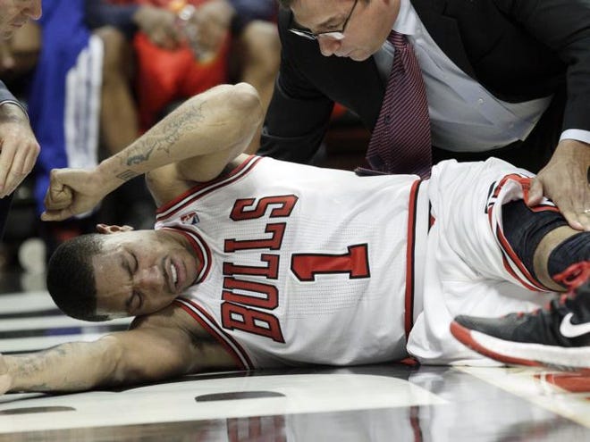 Chicago Bulls guard Derrick Rose (1) reacts after an injury during the fourth quarter of  Game 1 in the first round of the NBA basketball playoffs against the Philadelphia 76ers in Chicago, Saturday, April 28, 2012. The Bulls won 103-91.