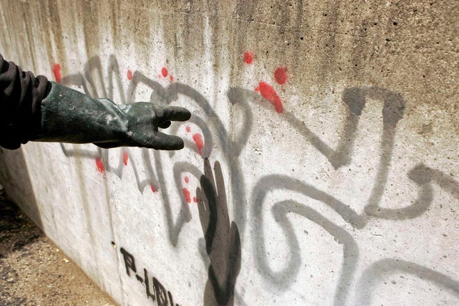 A City of Rockford employee, who wished not to be named for his safety, shows graffiti on a wall Friday, April 27, 2012, at Hilander on Mulford Road in Rockford.