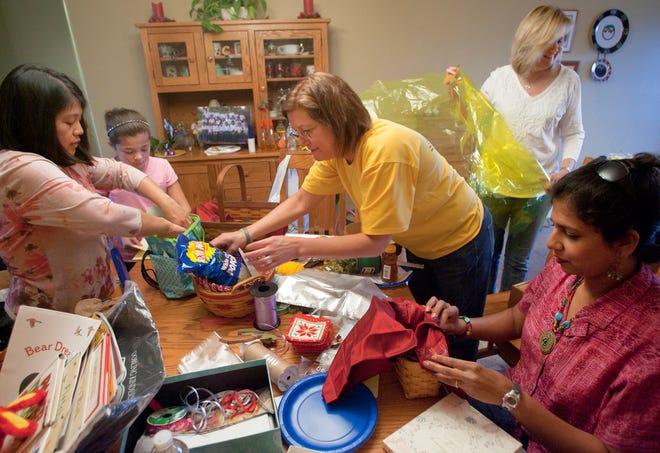 From left, Ima and Morgan Parriott, MaryAnn Cherry, Caren Hughs and Saira Wahab-Silas assemble baskets for the upcoming Myanmar Hope Christian Mission fundraiser at the home of MaryAnn and Chuck Cherry Tuesday, April 24, 2012.