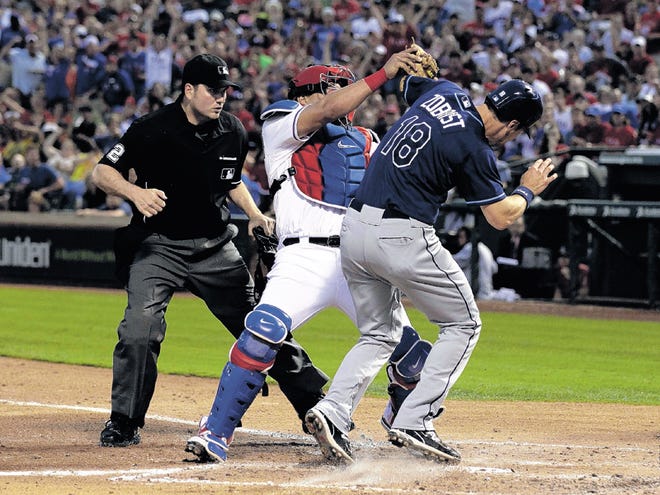 Home plate umpire Dan Bellino, left, watches as Texas Rangers catcher Yorvit Torrealba, center, fights off a collision with Tampa Bay Rays' Ben Zobrist (18) at the plate in the third inning of a baseball game Sunday, April 29, 2012, in Arlington, Texas. Zobrist, who was trying to advance on a single by B.J. Upton, was out on the play.
