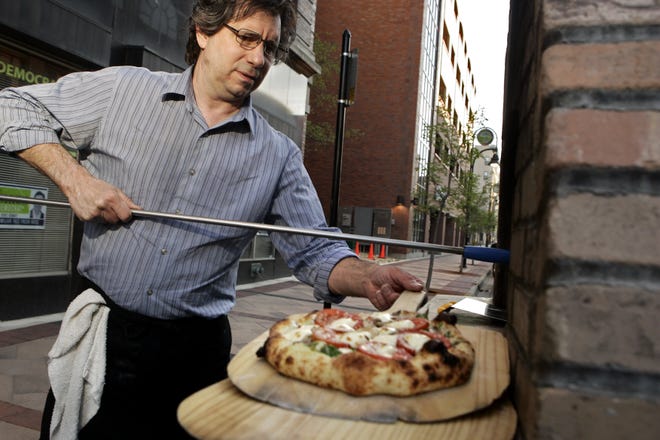 Joe D'Astice makes pizzas from Woodfire Brick Oven Pizza Wednesday, March 28, 2012, at Kryptonite in Rockford.