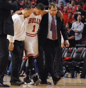 Chicago Bulls point guard Derrick Rose is assisted off the court after injuring his leg in the fourth quarter of Game 1 in the first round of the NBA basketball playoffs against the Philadelphia 76ers in Chicago Saturday. The Bulls won 103-91. (AP Photo/Daily Herald, John Starks)