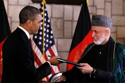 President Barack Obama and Afghan President Hamid Karzai sign a strategic partnership agreement at the presidential palace in Kabul, Afghanistan, Wednesday, May 2, 2012.
