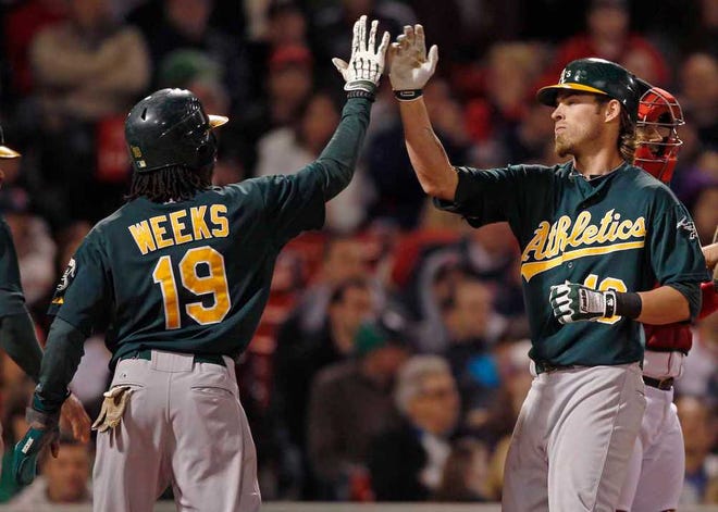 Charles Krupa/The Associated PressOakland Athletics right fielder Josh Reddick (16) is congratulated by teammate Jemile Weeks, left, after his three-run homer against Boston Red Sox starting pitcher Clay Buchholz during the seventh inning of a baseball game at Fenway Park in Boston on Monday.