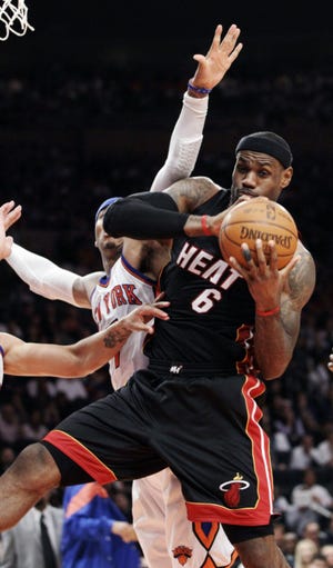 Miami Heat forward LeBron James (6) pulls down a rebound in front of New York Knicks forward Carmelo Anthony (left) in Game 3 of their NBA basketball first-round playoff series at Madison Square Garden in New York, Thursday. James scored 32 points as the Heat won 87-70. (AP Photo/Kathy Willens)