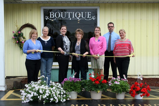Kathy’s Flower Patch owner Kathy Mesecar (center) stands surrounded by Lakewood Area Chamber of Commerce ambassadors and community members before cutting the ribbon during a ceremony Friday.