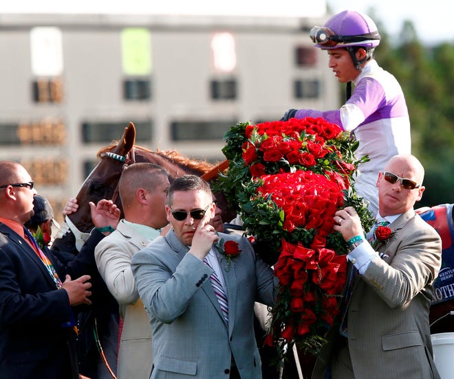 The bed of roses is removed from the lap of jockey Mario Gutierrez atop I'll Have Another, after winning the 138th running of the Kentucky Derby at Churchill Downs in Louisville, KY Saturday afternoon, May 5, 2012. The historic race set a new record with over 165,000 attending.