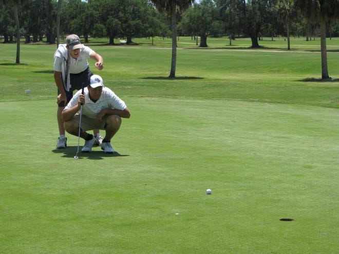 Top challenger Michael Visacki of Sarasota lines up a putt with help from caddy Austin Drechsler during the third round of the city men's golf championship Saturday.