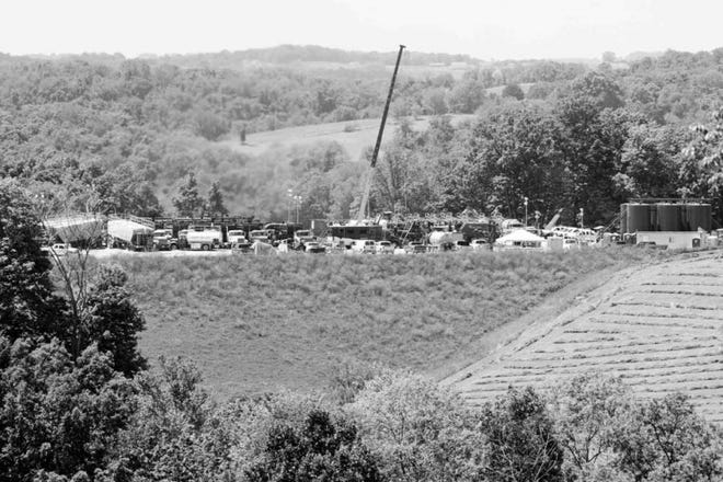 A crane towers over pumps and storage bins at a natural gas production site near Claysbille, Pa.