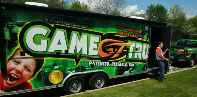 Scott Beskid steps out of the Game Truck, a truck filled with high definition TVs and video games that people can rent for parties. The truck, which can hold up to 30 people, is the first business venture for the stay at home dad. (Ed Suba Jr./Akron Beacon Journal)