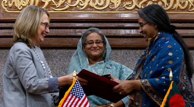 Bangladesh Prime Minister Sheikh Hasina, center, looks on as U.S. Secretary of State Hillary Rodham Clintonand and Bangladesh Foreign Minster Dipu Moni exchange signed agreements in Dhaka, Bangladesh, Saturday. Clinton is in Bangladesh to press tolerance, democracy and development in one of the world's most impoverished nations that is now in the throes of political turmoil. (AP Photo/Pavel Rahman)