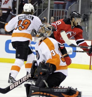 New Jersey's Dainius Zubrus (right rear) celebrates after scoring a goal against Philadelphia goalie Ilya Bryzgalov while Flyers' Scott Hartnell skates past during the second period Sunday.