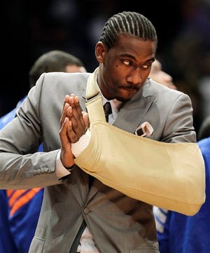 New York Knicks forward Amare Stoudemire watches from the baseline with his arm in a sling before Game 3 of an NBA basketball first-round playoff series at Madison Square Garden in New York, Thursday, May 3, 2012. Stoudemire sat the game out after a surgeon repaired a muscle in his hand Tuesday after he cut it punching through the glass of a fire extinguisher case following Game 2. (AP Photo/Kathy Willens)