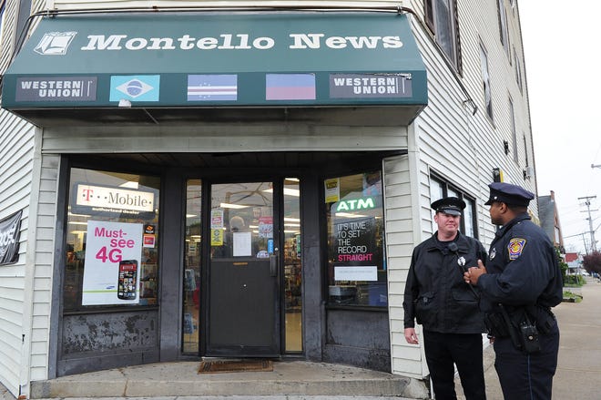 Brockton police officers Anthony Louis, right, and Eric Burke discuss their patrol outside Montello News on North Main Street. Montello business owners say they are pleased with the new police foot patrols.