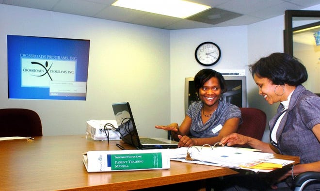 Tia Sanders (left), LCSW, program director, and Laura Hooker-Jackson of Willingboro (right) who has a foster child, work together prepping for a presentation.