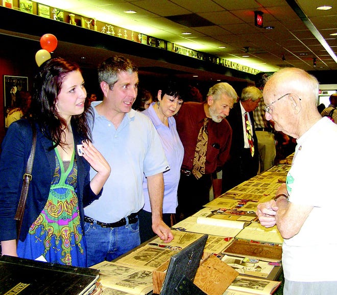 Patti Kotrady and her father Anthony visit with Richard Walck, who shared a display of World War II memorabilia. It drew many visitors before and after the program on veterans and Holocaust survivors.